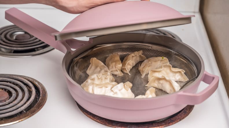 Pink pan with dumplings steaming inside.