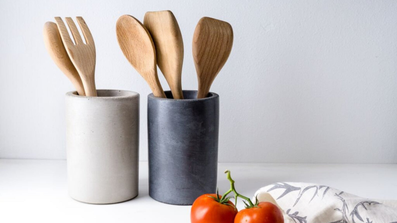 Two utensil holders house spatulas and spoons.