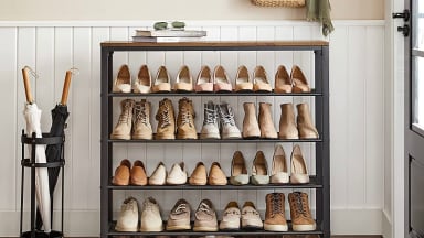 An industrial looking shoe rack placed in the hallway of a home.