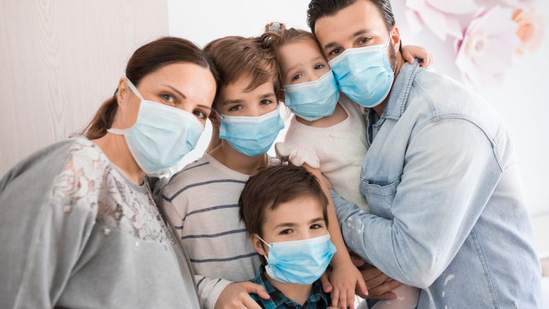 A family of five all wearing face masks