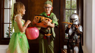 穿万圣节服装的三个孩子：Tinker Bell，Peter Pan和曼德拉多利亚