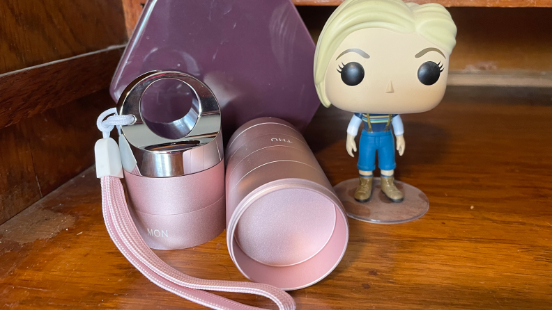 The Zannaki Metal Travel Pill Organizer next to a Funko Pop figurine