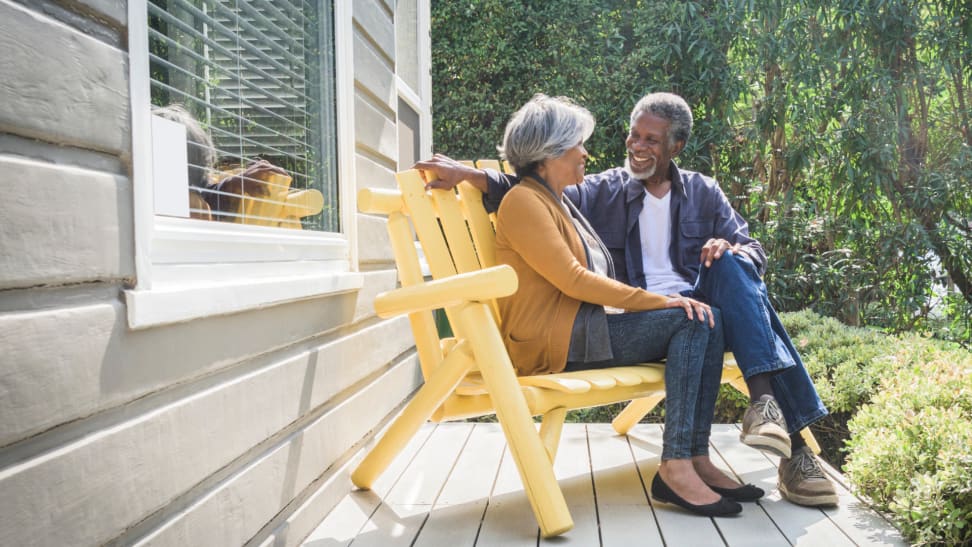 A couple sits on an outside porch.