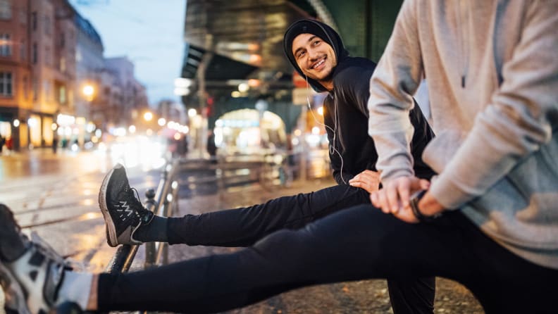 Two men stretching before a run.