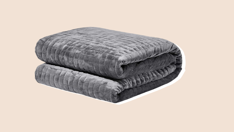 A gray soft quilted washable Gravity weighted blanket with soft microfiber on a neutral background.