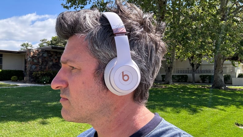 A man wearing Slate Pink Beats Solo 4 headphones outside.