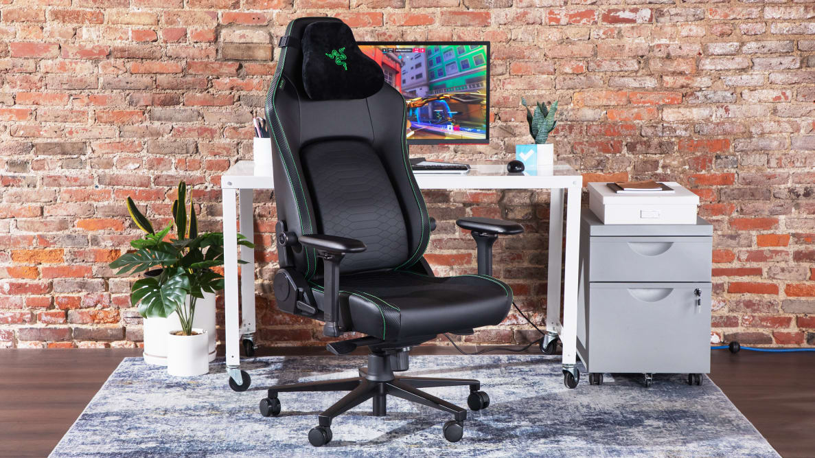 A close-up of the Razer Iskur V2 gaming chair in a media room against a brick wall