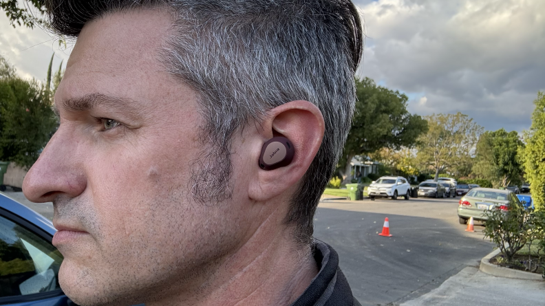 A man wearing the earbud inside his ear.