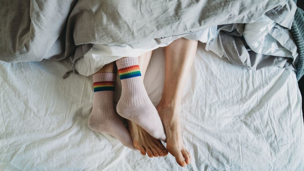 a couple under covers one sleeping with socks and one without