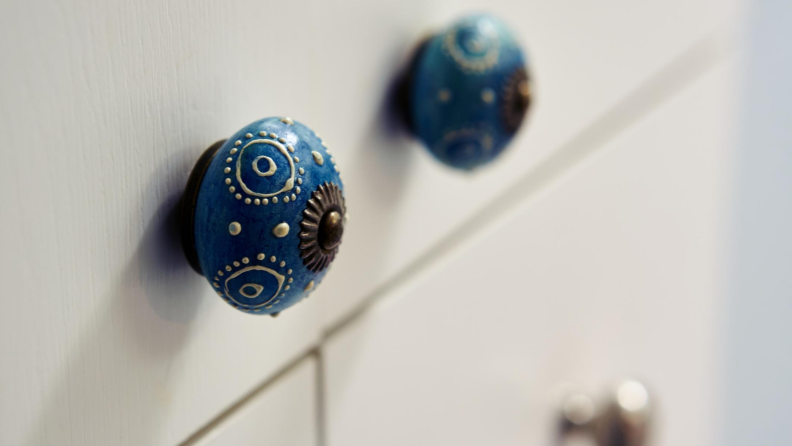 Two blue and white painted circular cabinet knobs