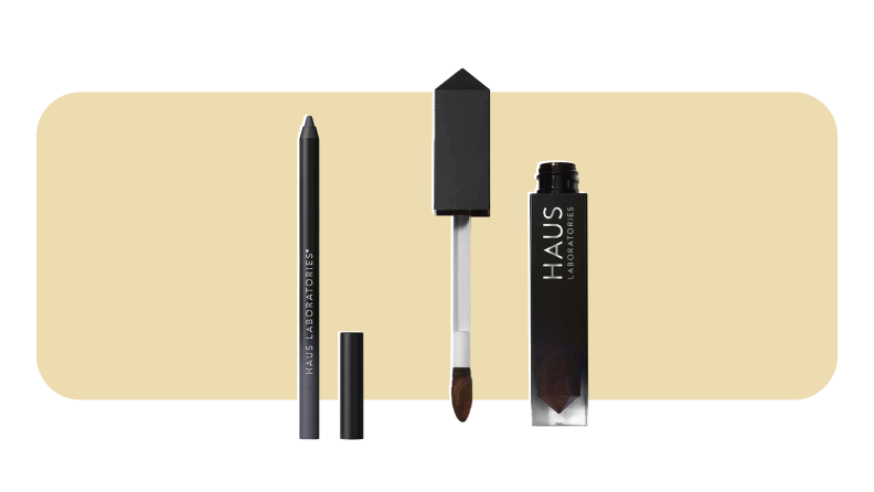 A black eyeliner pencil and a black tube of lip gloss next to each other.