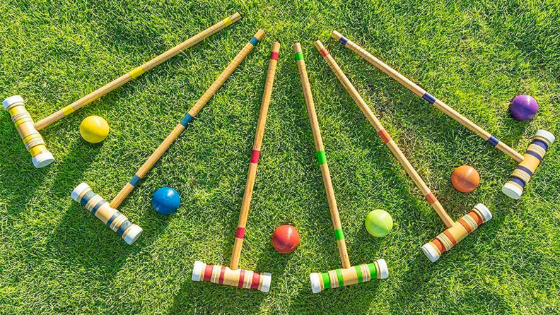 Croquet equipment lays in the grass.