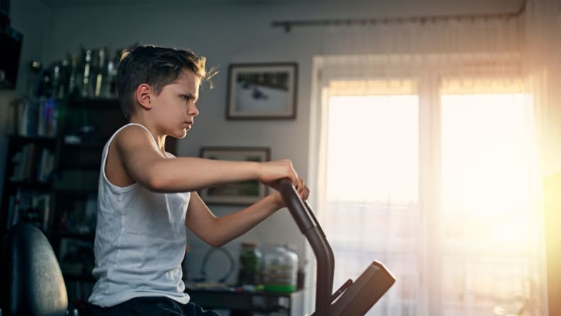 A young child uses an exercise bike.