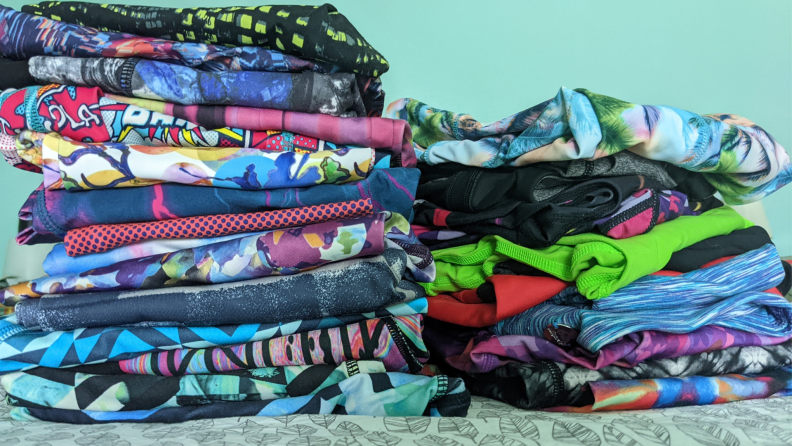 Two piles of folded colorful workout leggings
