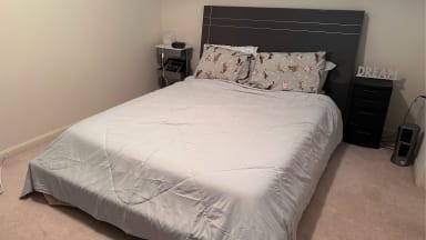 Gray Cozy Bliss comforter on a full-sized bed in a bedroom with beige walls and a brown headboard.