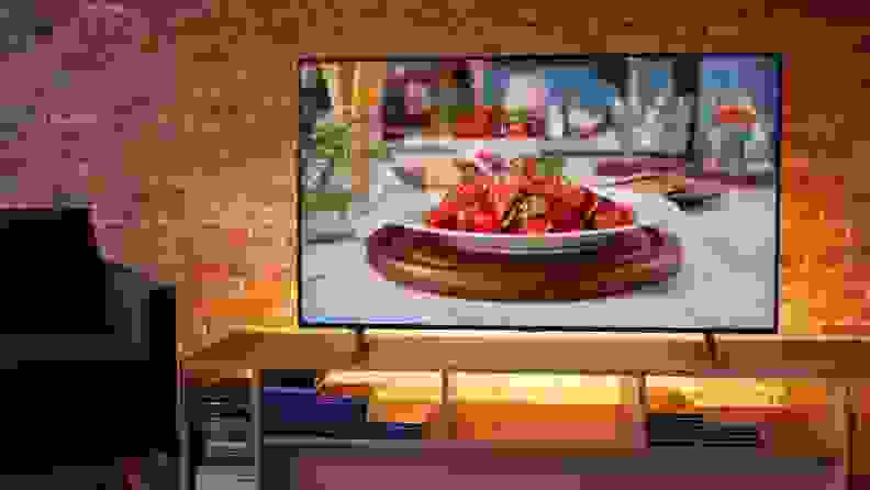 Samsung TV sitting in a living room, displaying a cooking show.