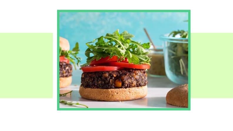 Veggie burger with protein, tomatoes, and arugula with no top bun.