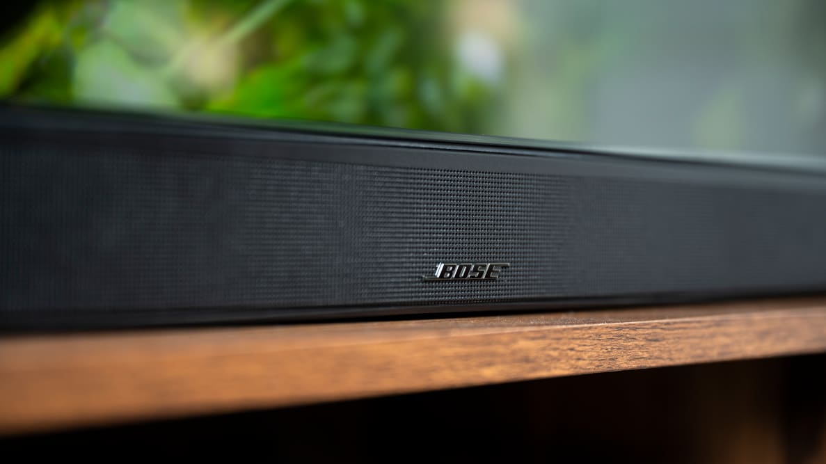 The all-black Bose 900 is zoomed in to show the metal grill up close and personal, with a metallic Bose logo at the center.