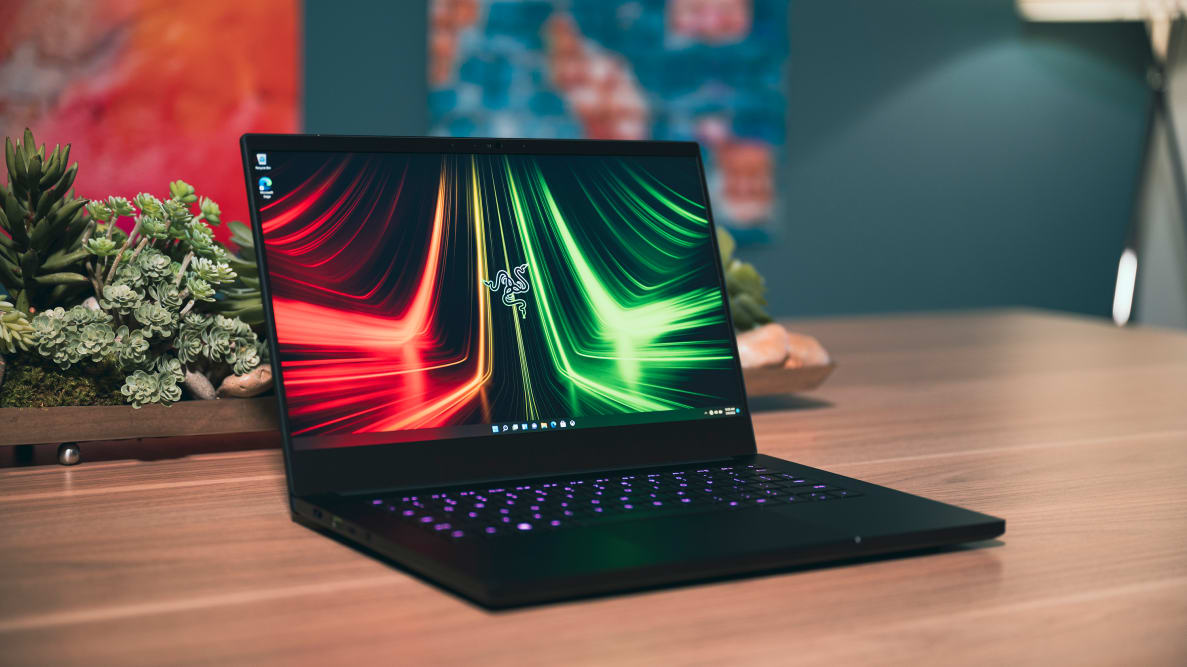 A powered-on black laptop showing streaks of red and green light across its screen.