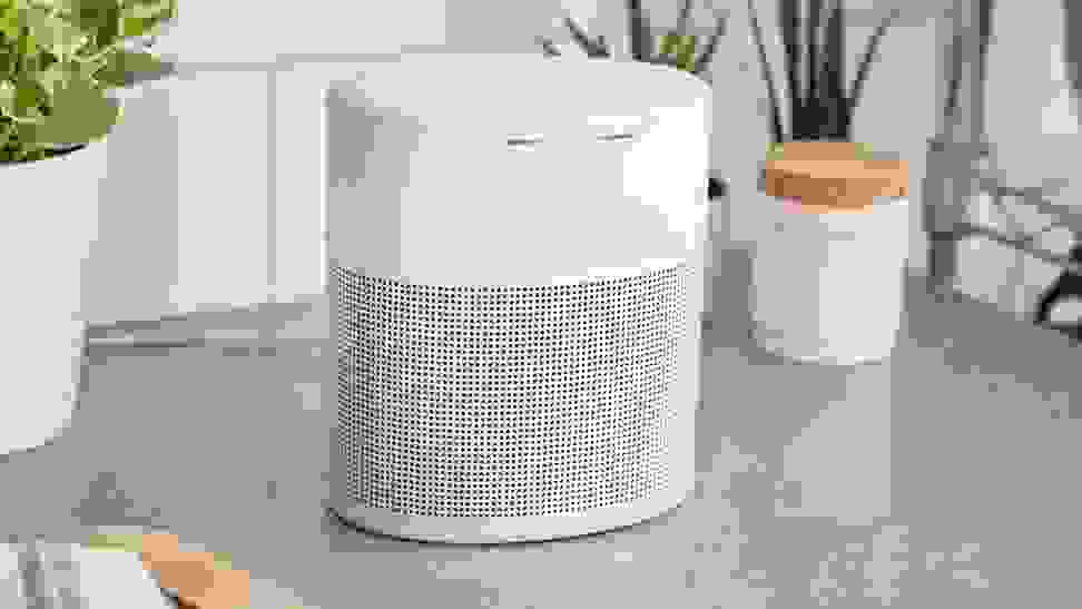 Silver and white Bose Home 300 smart speaker on kitchen counter with plants and cutting board