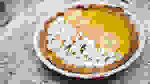 A pumpkin pie with scorched meringue and pumpkin-shaped cookies on top.