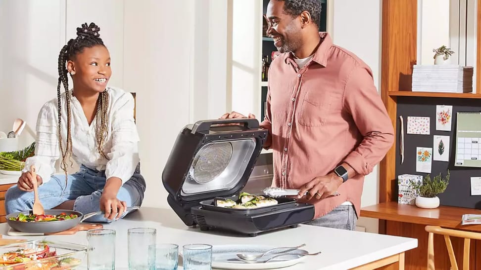 A man and young woman in a kitchen with appliances