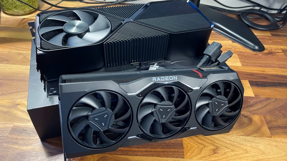 The Nvidia RTX 4080 Super and the AMD Radeon RX 7900 XTX side by side on a desk.