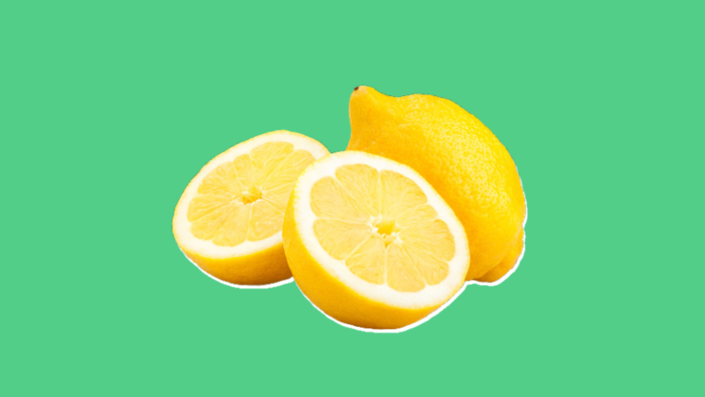 Two lemons, one sliced in half, on a green background.