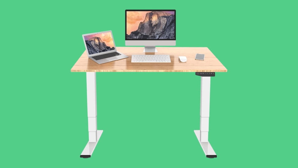 A Flexispot Standing Desk exists over a green space.
