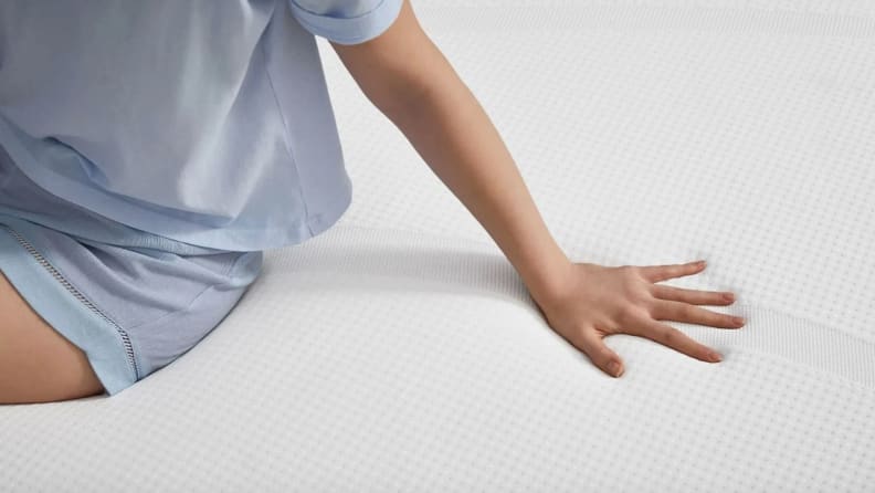 a woman pushes her hand on the Tempur-Cloud mattress