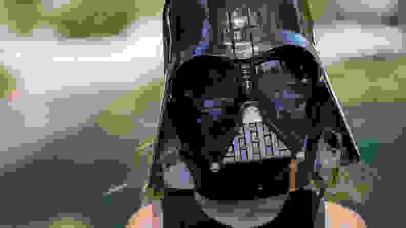A child wears a shipDisney Darth Vader mask.