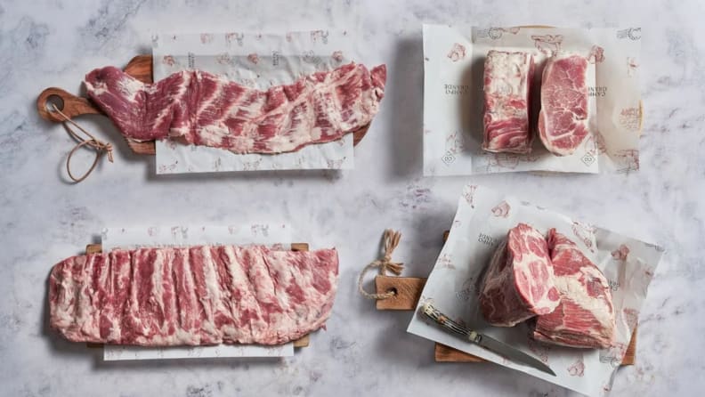 Picture of assorted raw meats on marble surface.