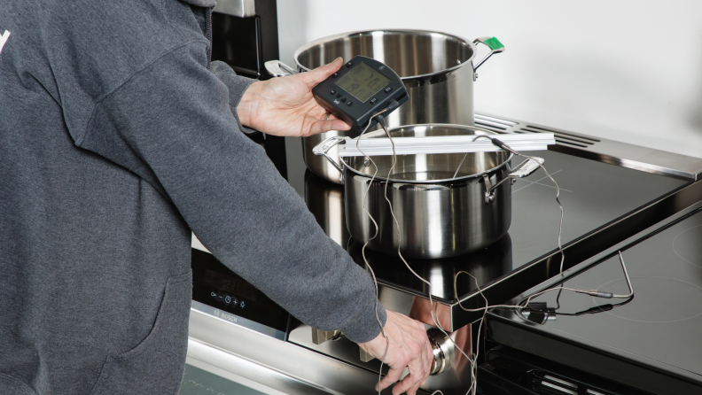 A Reviewed Kitchen editor measuring how fast the range's burner can bring water to a boil.