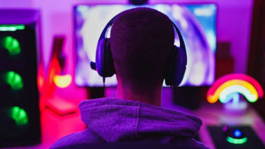 A person wearing headphones and sitting in front of a computer monitor