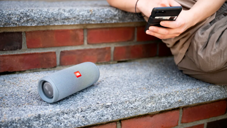 A portable Blutooth speaker on a bench.