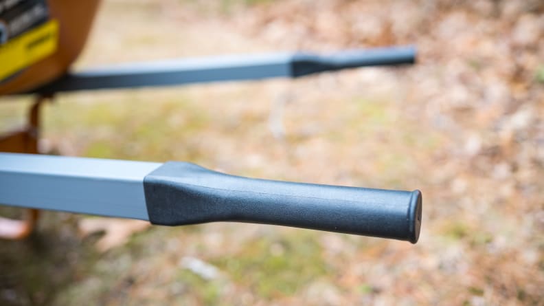 A close-up of black plastic wheelbarrow handles.