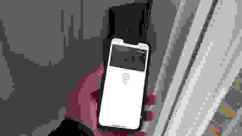 A person holding a phone to a door lock