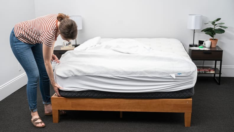 a person makes the bed with the slumber cloud core protector