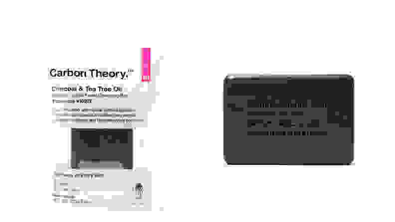 On the left: The Carbon Theory Charcoal & Tea Tree Oil Break-Out Control Facial Cleansing Bar inside its packaging sits on a white background. On the right: The dark gray Carbon Theory Charcoal & Tea Tree Oil Break-Out Control Facial Cleansing Bar sits on a white background. it has words imprinted on to it.