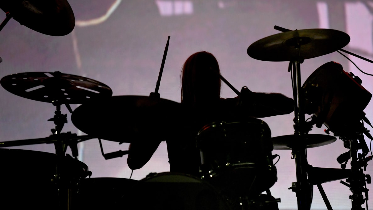 喷火战机乐队(Foo Fighters)的泰勒·霍金斯(Taylor Hawkins)坐在一套架子鼓后面(剪影)。