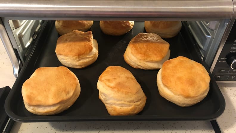 A tray of golden brown biscuits comes out of the Ninja Foodi oven.