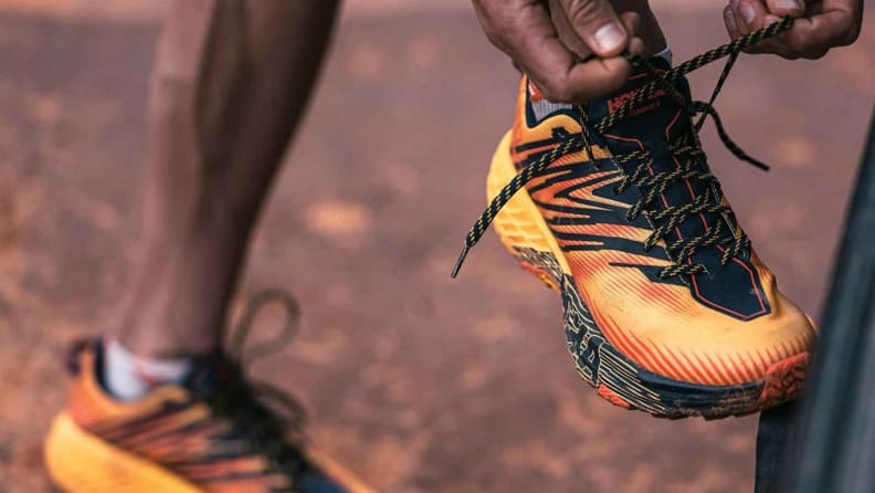 Black man tying Hoka shoes