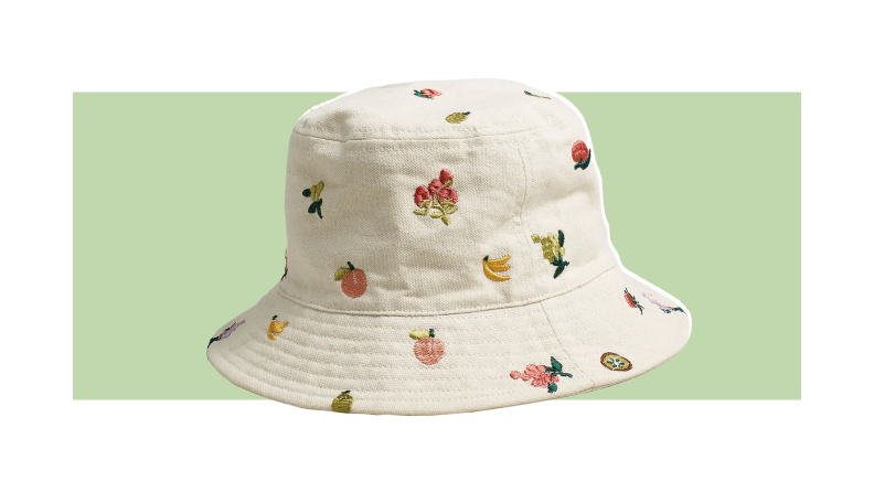 A white bucket hat embroidered with fruits and flowers.
