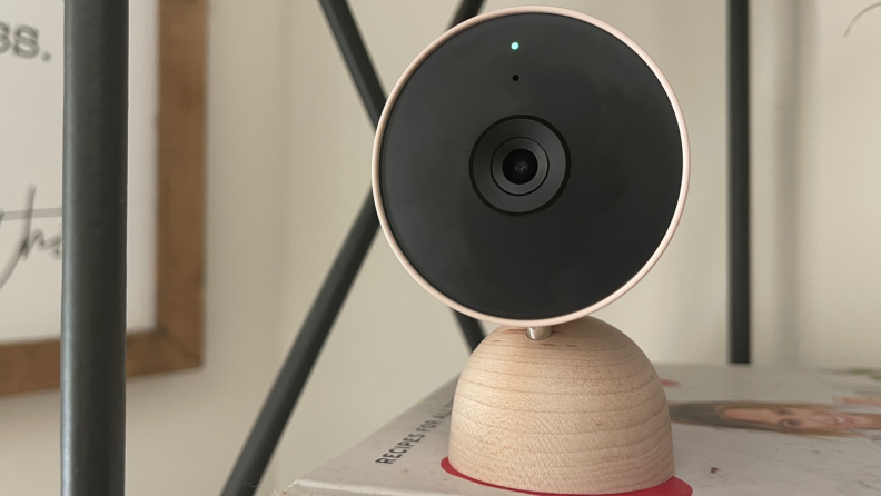 The Google Nest Cam (indoor, wired) sits on a bookshelf