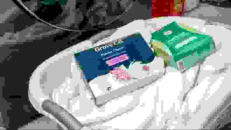 A box of Grove Co. Power Clean laundry sheets in a basket.