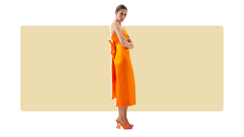 A columnar orange satin midi dress with a foldover neckline and a bow on the back.