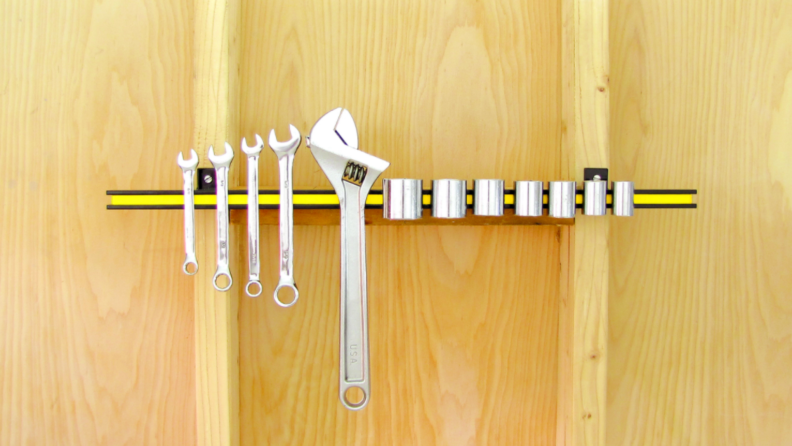 Magnetic strip board holding metal tools to a wall