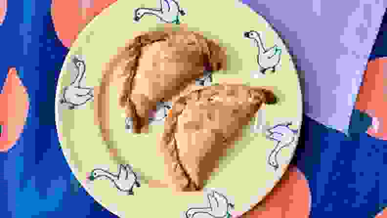 Two empanadas on a patterned plate.