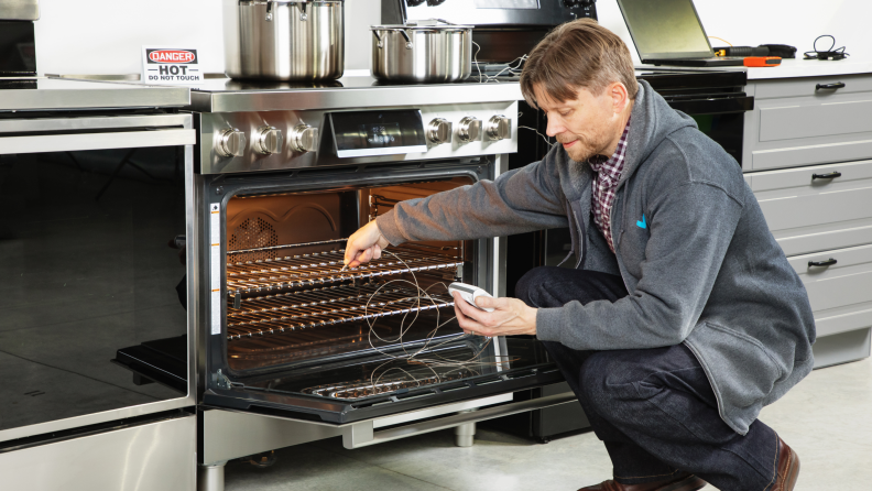 A Reviewed Kitchen editor testing the inside of the range oven.