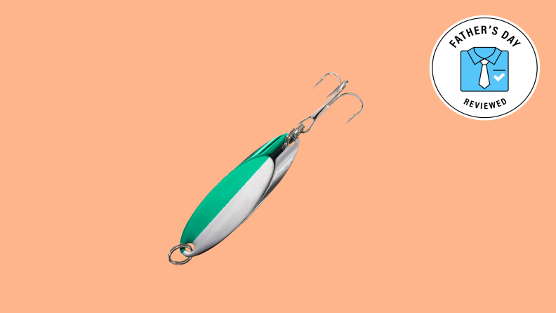 A green and white fishing lure set against a light orange background.